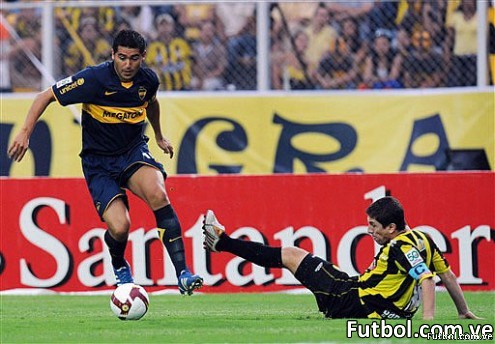Juan Román Riquelme (izq.) del Boca Juniors disputa un balón con el defensa del Deportivo Táchira. AFP Photo / Juan Barreto